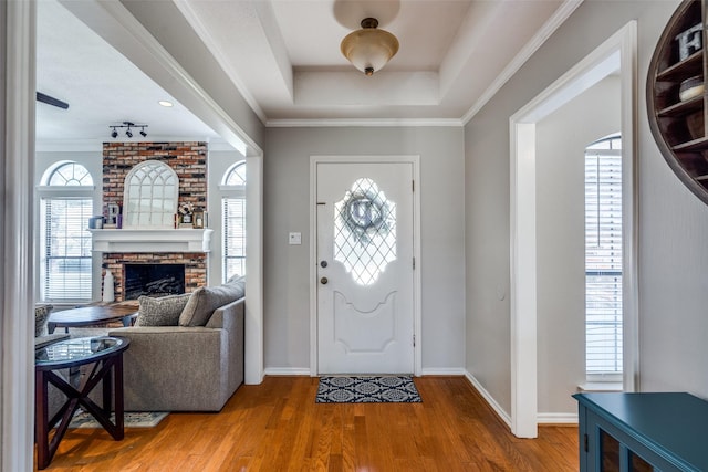 2332 Heatherwoods Way, Carrollton, TX 75007 - entryway featuring wood finished floors, a fireplace, baseboards, a tray ceiling, and ornamental molding