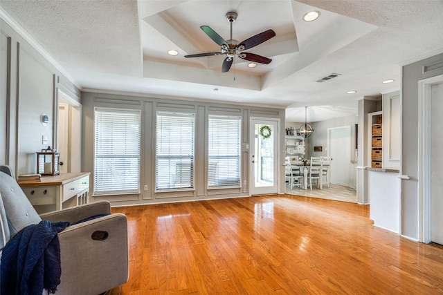 2332 Heatherwoods Way, Carrollton, TX 75007 - living room with a ceiling fan, light wood-style flooring, a raised ceiling, ornamental molding, and recessed lighting