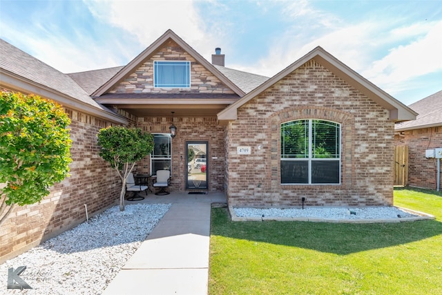 4709 Spring Creek Rd, Abilene, TX 79602 - entrance to property featuring brick siding, a lawn, a chimney, and roof with shingles