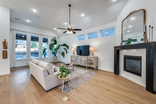 3201 Sunday Silence Ln, Celina, TX 75009 - living room featuring lofted ceiling, plenty of natural light, wood finished floors, a tiled fireplace, and recessed lighting