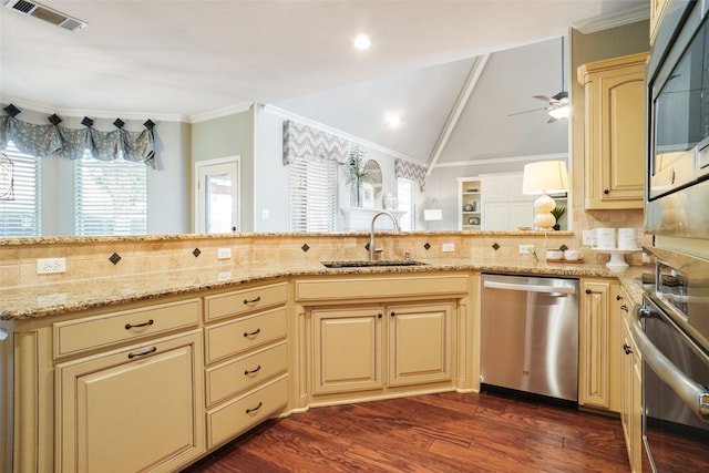 4112 Paddington Ln, Colleyville, TX 76034 - kitchen with stainless steel appliances, a sink, cream cabinetry, dark wood-type flooring, and crown molding