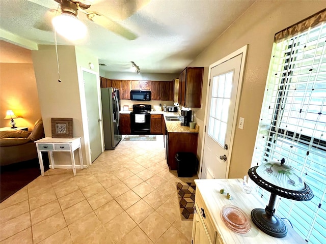 328 Branson Rd, Roanoke, TX 76262 - kitchen featuring black appliances, light countertops, light tile patterned flooring, a textured ceiling, and open floor plan