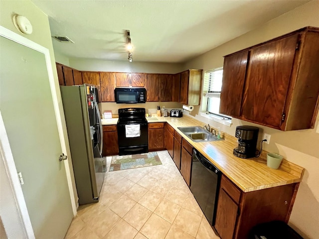 328 Branson Rd, Roanoke, TX 76262 - kitchen with black appliances, a sink, light countertops, and light tile patterned flooring