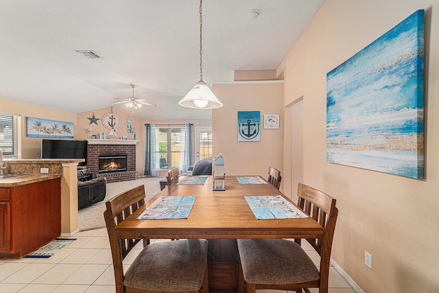 4720 Topaz Ln, Granbury, TX 76049 - dining room featuring ceiling fan, a fireplace, lofted ceiling, light tile patterned floors, and baseboards