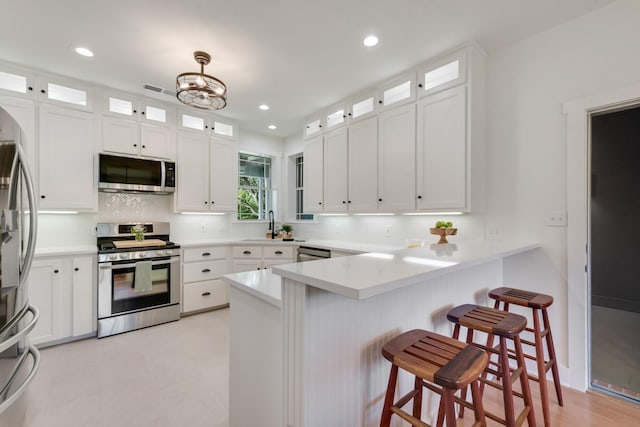 3829 Fm 896, Leonard, TX 75452 - kitchen with stainless steel appliances, a peninsula, a breakfast bar area, white cabinets, and recessed lighting