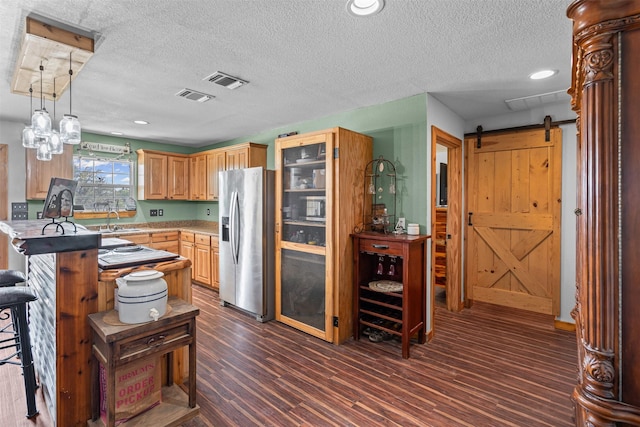 227 W Lipan Dr, Lipan, TX 76462 - kitchen featuring appliances with stainless steel finishes, a peninsula, a breakfast bar, a textured ceiling, and a sink