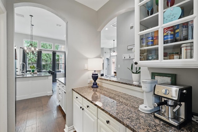 1416 Basil Dr, Flower Mound, TX 75028 - bar with arched walkways, dark wood-type flooring, a chandelier, hanging light fixtures, and recessed lighting
