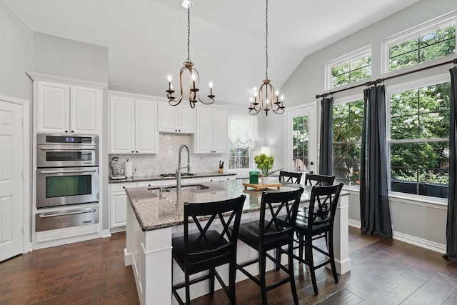 1416 Basil Dr, Flower Mound, TX 75028 - kitchen with a warming drawer, a chandelier, double oven, vaulted ceiling, and decorative backsplash