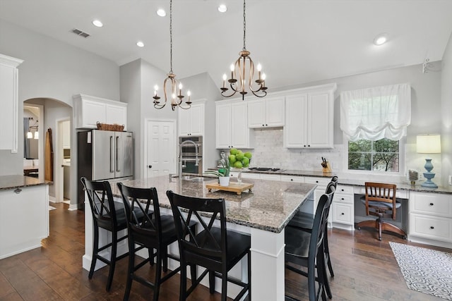 1416 Basil Dr, Flower Mound, TX 75028 - kitchen with stainless steel appliances, arched walkways, tasteful backsplash, a chandelier, and dark stone countertops
