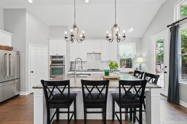 1416 Basil Dr, Flower Mound, TX 75028 - kitchen featuring stainless steel appliances, a sink, a chandelier, lofted ceiling, and tasteful backsplash