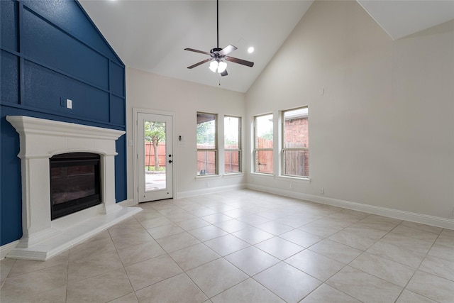 10909 Blake Gdns, Mckinney, TX 75072 - unfurnished living room with a ceiling fan, light tile patterned floors, high vaulted ceiling, a glass covered fireplace, and baseboards