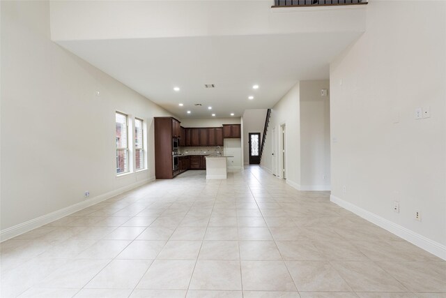 10909 Blake Gdns, Mckinney, TX 75072 - unfurnished living room with light tile patterned floors, recessed lighting, baseboards, and a sink