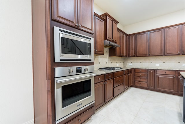 10909 Blake Gdns, Mckinney, TX 75072 - kitchen featuring appliances with stainless steel finishes, tasteful backsplash, and light stone countertops