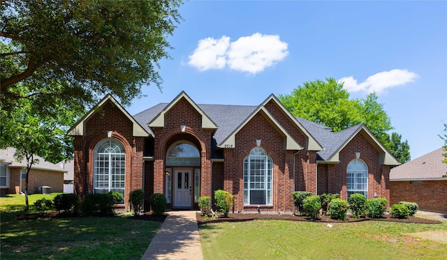 3015 Oak Dr, Rockwall, TX 75032 - view of front of house with brick siding, a front lawn, and a shingled roof