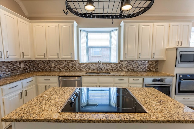 3015 Oak Dr, Rockwall, TX 75032 - kitchen with appliances with stainless steel finishes, a sink, white cabinetry, light stone countertops, and ornamental molding