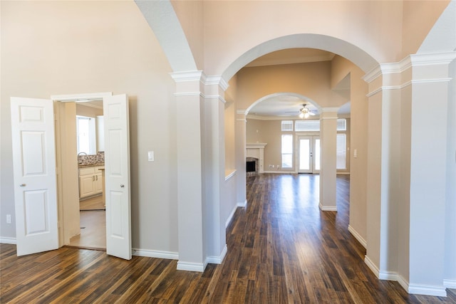 3015 Oak Dr, Rockwall, TX 75032 - corridor with arched walkways, dark wood-type flooring, ornate columns, a high ceiling, and baseboards