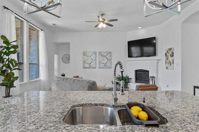 1805 13th St, Argyle, TX 76226 - kitchen with open floor plan, a sink, light stone countertops, and a fireplace