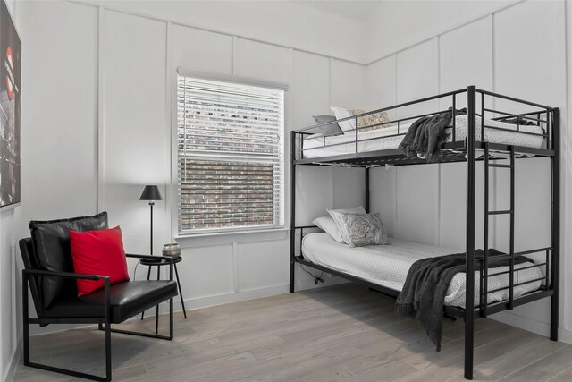 1805 13th St, Argyle, TX 76226 - bedroom with light wood-style flooring, baseboards, and a decorative wall