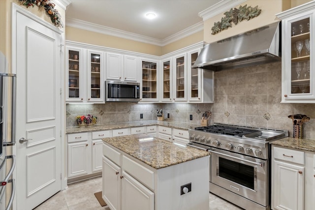 3351 Cascades Ct Unit 306, Tyler, TX 75709 - kitchen with appliances with stainless steel finishes, ventilation hood, crown molding, white cabinets, and tasteful backsplash