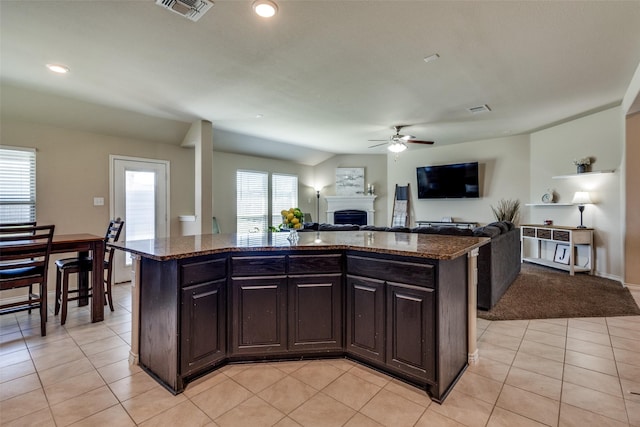2613 Hillrich Dr, Anna, TX 75409 - kitchen with a ceiling fan, dark stone countertops, a fireplace, open floor plan, and light tile patterned floors