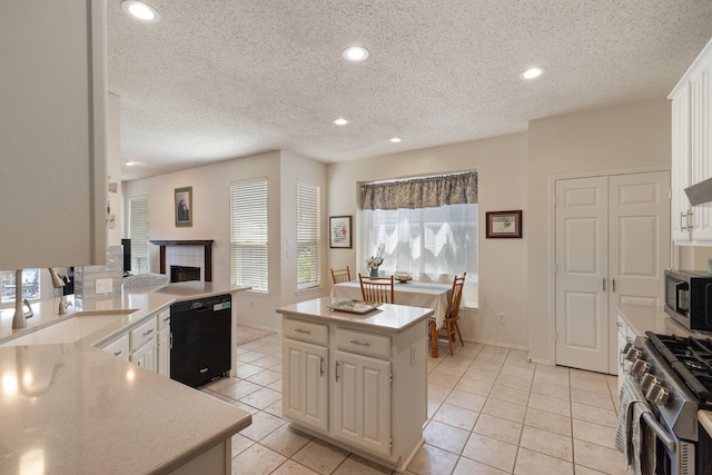 3942 Luke Ln, Carrollton, TX 75007 - kitchen featuring appliances with stainless steel finishes, light countertops, light tile patterned floors, a textured ceiling, and white cabinets