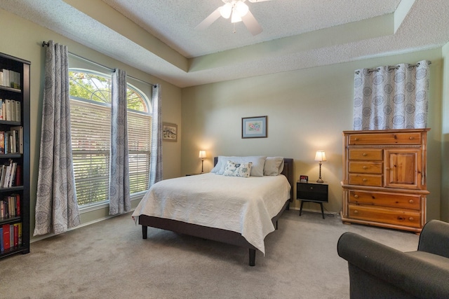 3942 Luke Ln, Carrollton, TX 75007 - carpeted bedroom with a tray ceiling, a textured ceiling, and ceiling fan