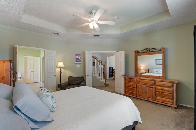 3942 Luke Ln, Carrollton, TX 75007 - bedroom with a tray ceiling, light carpet, a textured ceiling, and ceiling fan