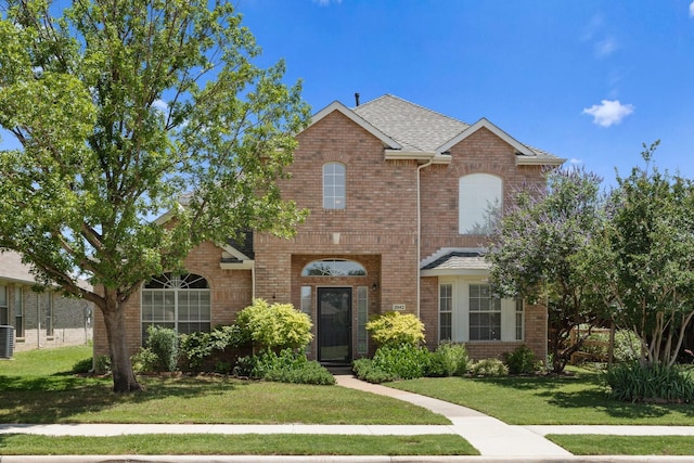 3942 Luke Ln, Carrollton, TX 75007 - traditional-style house featuring a front lawn, brick siding, and a shingled roof