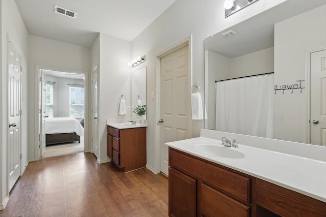 5321 Threshing Dr, Fort Worth, TX 76179 - bathroom featuring wood finished floors, two vanities, ensuite bath, and baseboards