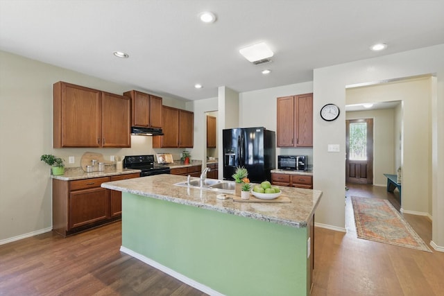 5321 Threshing Dr, Fort Worth, TX 76179 - kitchen featuring black appliances, under cabinet range hood, a sink, dark wood-style floors, and an island with sink