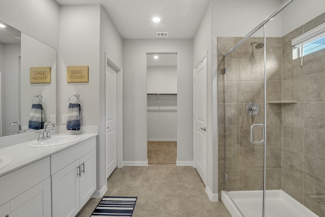 2105 Rolling Wild Rd, Forney, TX 75126 - bathroom with a stall shower, double vanity, a walk in closet, and baseboards