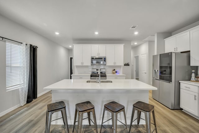 2105 Rolling Wild Rd, Forney, TX 75126 - kitchen with stainless steel appliances, a sink, decorative backsplash, light wood-style flooring, and recessed lighting