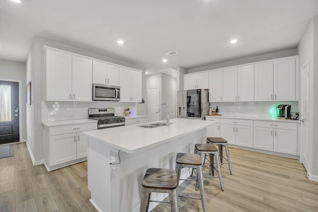 2105 Rolling Wild Rd, Forney, TX 75126 - kitchen with appliances with stainless steel finishes, a sink, decorative backsplash, a kitchen bar, and recessed lighting