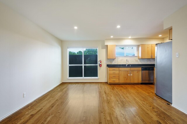 4616 W Lovers Ln Unit 119, Dallas, TX 75209 - kitchen featuring stainless steel appliances, dark countertops, decorative backsplash, light wood-style floors, and a sink