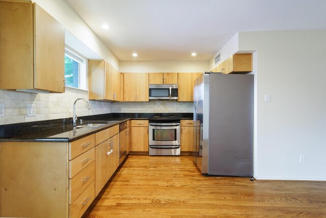 4616 W Lovers Ln Unit 119, Dallas, TX 75209 - kitchen featuring appliances with stainless steel finishes, a sink, light wood-style flooring, backsplash, and light brown cabinets