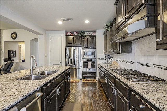 955 Champions Way, Roanoke, TX 76262 - kitchen with appliances with stainless steel finishes, a sink, light stone counters, dark wood-style floors, and decorative backsplash