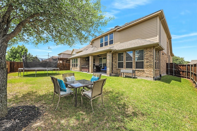 955 Champions Way, Roanoke, TX 76262 - back of house featuring a trampoline, a patio area, a jacuzzi, and brick siding