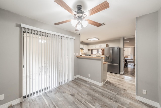 5622 Polo Club Dr, Arlington, TX 76017 - kitchen featuring stainless steel fridge with ice dispenser, a peninsula, ceiling fan, light wood-style floors, and baseboards