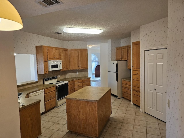 404 L Thompson St, Cedar Hill, TX 75104 - kitchen with white appliances, wallpapered walls, light tile patterned floors, a center island, and a textured ceiling