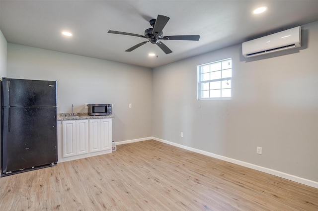 3614 County Road 902, Joshua, TX 76058 - unfurnished room featuring a wall mounted AC, light wood-type flooring, a sink, baseboards, and recessed lighting