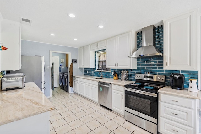 5240 Hill Ridge Dr, Fort Worth, TX 76135 - kitchen with appliances with stainless steel finishes, wall chimney range hood, independent washer and dryer, a sink, and decorative backsplash