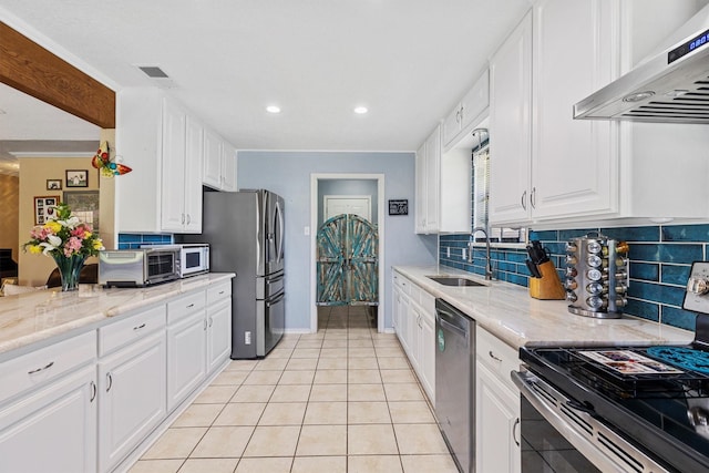 5240 Hill Ridge Dr, Fort Worth, TX 76135 - kitchen with appliances with stainless steel finishes, a sink, under cabinet range hood, light tile patterned floors, and decorative backsplash