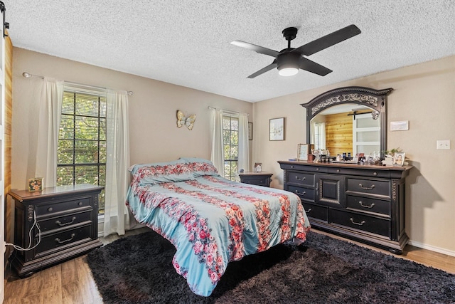 5240 Hill Ridge Dr, Fort Worth, TX 76135 - bedroom with wood finished floors, multiple windows, a textured ceiling, and ceiling fan