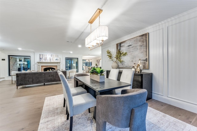 6702 Rolling Vista Dr, Dallas, TX 75248 - dining room with a brick fireplace, light wood-style flooring, recessed lighting, and a decorative wall