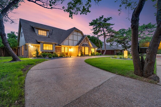 6702 Rolling Vista Dr, Dallas, TX 75248 - tudor house with curved driveway, brick siding, a yard, and a shingled roof