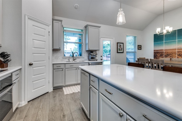 10009 Callan Ln, Fort Worth, TX 76131 - kitchen with gray cabinetry, stainless steel oven, lofted ceiling, a sink, and plenty of natural light