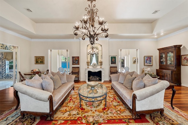 3012 Wood Lake Dr, Waco, TX 76710 - living area featuring a raised ceiling, a chandelier, wood finished floors, a fireplace, and crown molding