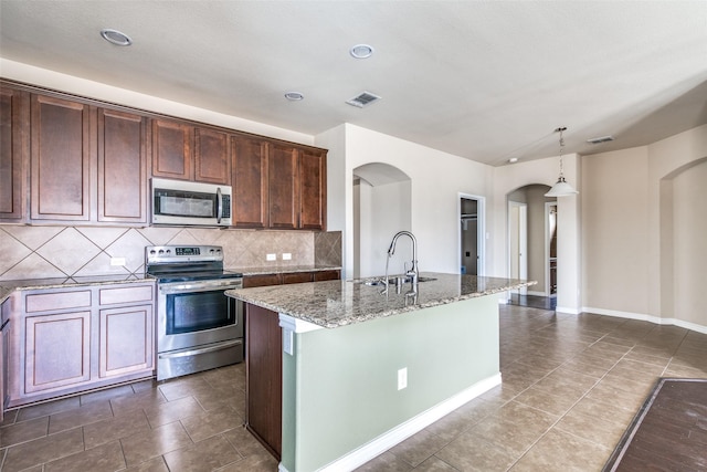 2520 Sabine Cir, Royse City, TX 75189 - kitchen with appliances with stainless steel finishes, a sink, arched walkways, light stone countertops, and decorative backsplash