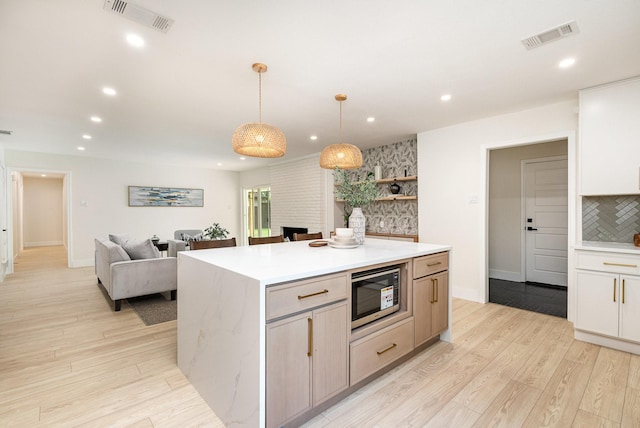7818 Rolling Acres Dr, Dallas, TX 75248 - kitchen with light countertops, recessed lighting, light wood-style floors, decorative backsplash, and a kitchen island