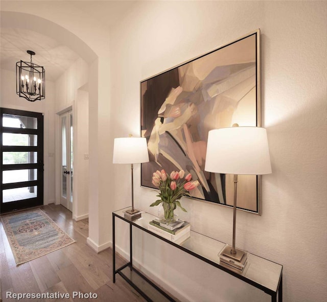 8413 Peach St, Justin, TX 76247 - foyer with wood finished floors, a chandelier, baseboards, and arched walkways